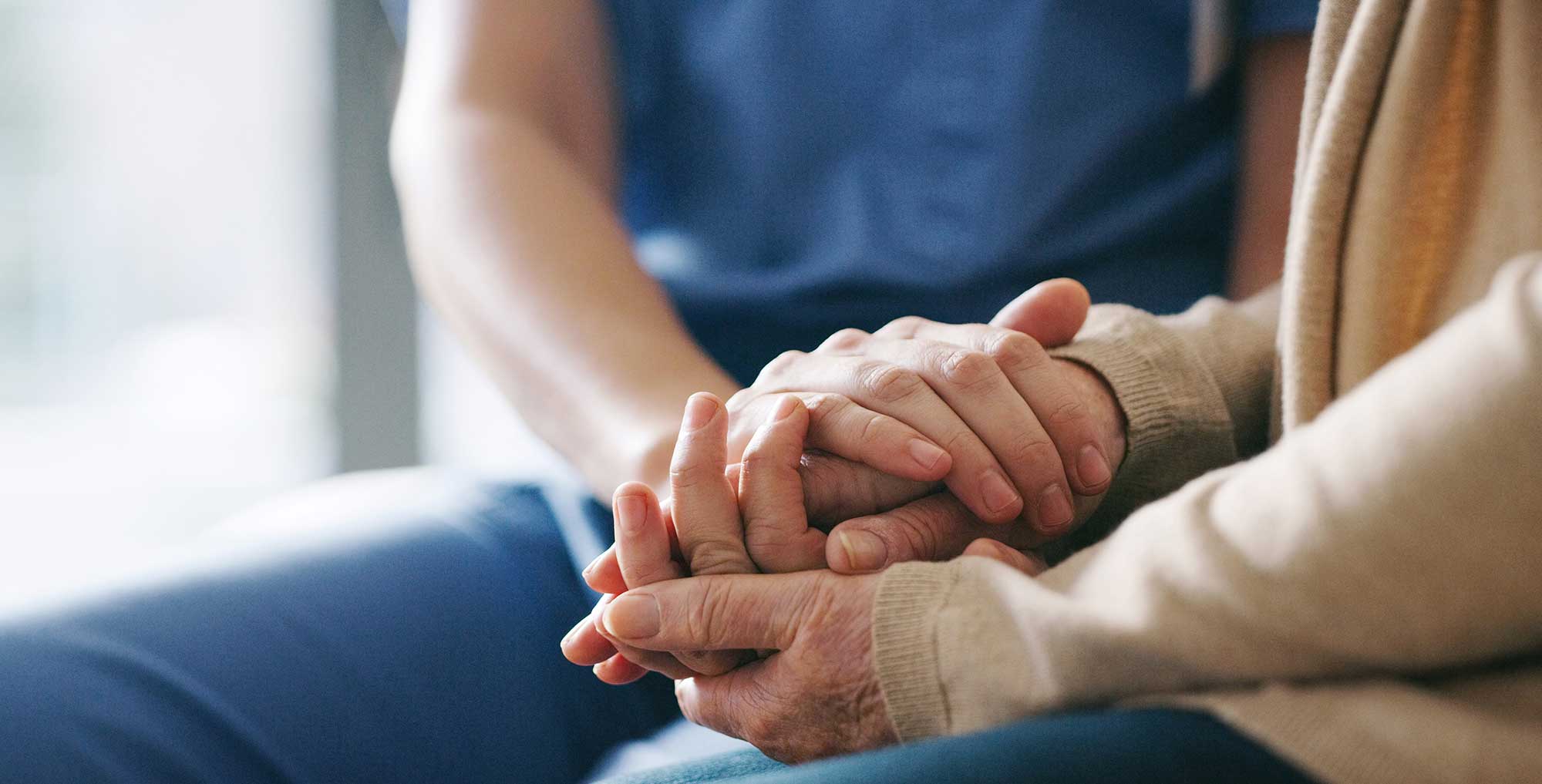 nurse holding patient's hand