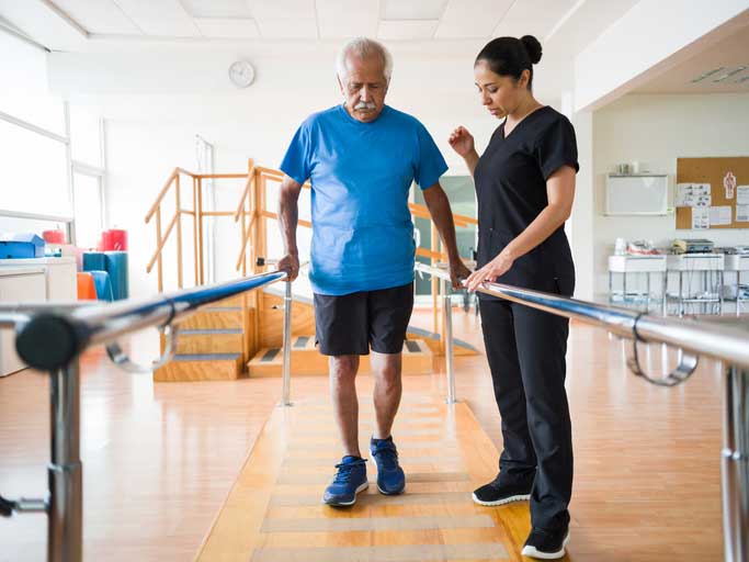 man walking with physical therapist
