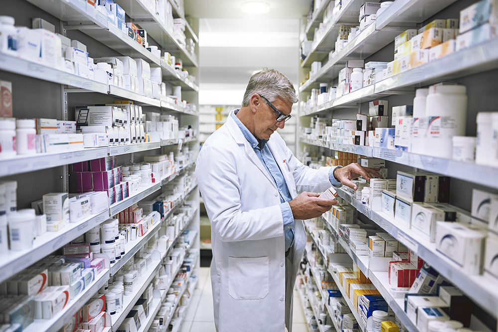 male pharmacist looking at prescriptions 